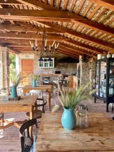 a patio with wooden tables and chairs and a ceiling at PusztaFarm - Boutique Retreat with Wellness 6 to 8 Guests in Fülöpháza