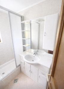 a white bathroom with a sink and a shower at Knusperhäuschen Nassfeld in Sonnenalpe Nassfeld