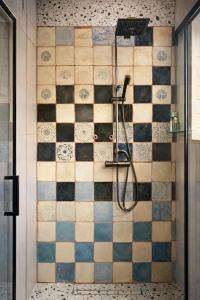 a shower in a bathroom with a tiled wall at Nastawka Cottage Creativity and Regeneration in Raciechowice