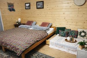 a bedroom with a bed and a wooden wall at Nastawka Cottage Creativity and Regeneration in Raciechowice