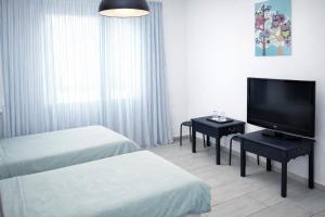 a hotel room with two beds and a flat screen tv at Hotel Road Rooms in Voluntari
