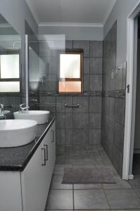 a bathroom with two sinks and a shower at River Bend Farm in Lidgetton