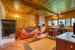 a family sitting in a living room with a red couch at Incanto Walser Apartments Testa in Macugnaga
