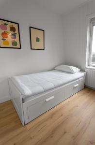 a bed in a bedroom with a white wall at Heggerank 5a in Nieuwvliet