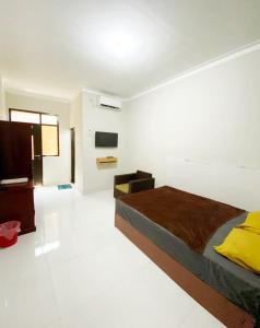 a bedroom with a bed and a television in it at Baga Guesthouse in Kanggraksan