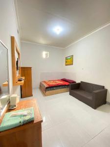 a room with a bed and a couch in it at Baga Guesthouse in Kanggraksan