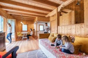 two children sitting on a couch in a living room at Incanto Walser Apartments Testa in Macugnaga