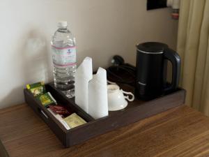 a wooden tray with a bottle of water and paper towels at Sri Gemunu Beach Resort in Unawatuna