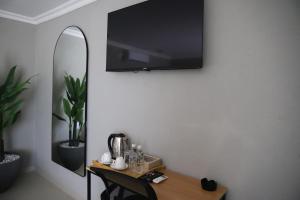 a room with a table with a tv on the wall at Amahle Guesthouse Bush in Dwarsloop