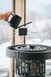 a person holding a pot over a grill at Wolter Landhaus in Vipiteno