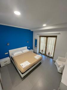 a bedroom with a large bed with a blue wall at Le Ghie in Mondovì