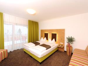 una camera da letto con un letto grande e una grande finestra di Der Seebacherhof a Tauplitz