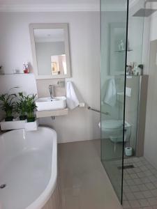 a bathroom with a sink and a toilet and a mirror at Agulhas Splendour in Agulhas