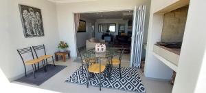 a dining room and living room with a glass table and chairs at Agulhas Splendour in Agulhas