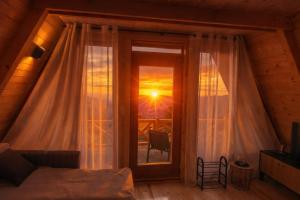 a bedroom with a window with a view of the sunset at Komovi Luxury Sunset in Andrijevica