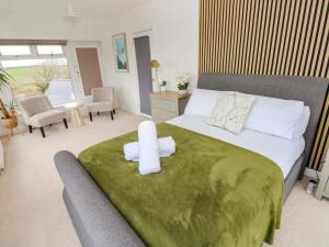 a bedroom with a large bed with a green blanket at Burry House in Swansea