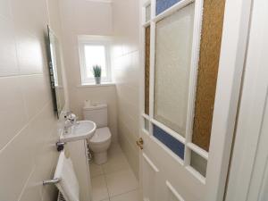 a bathroom with a toilet and a sink and a window at Burry House in Swansea +46 photos
