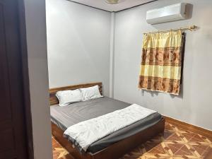 a small bedroom with a bed and a window at Fundee Guesthouse in Pakse +15 photos