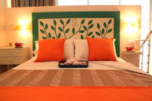 a bed with orange pillows and a green head board at Summa Resort in Roccasecca