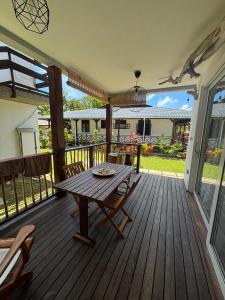 a wooden deck with a table and chairs on it at Reve Island Lodge in Grand Anse