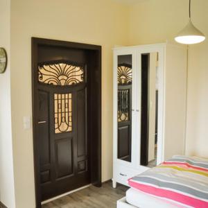 a room with a door and a bed and a mirror at Kleine Bella in Ilmmünster