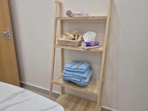 a wooden shelf with towels on it next to a bed at My SunArt in Quang Ãm +5 photos