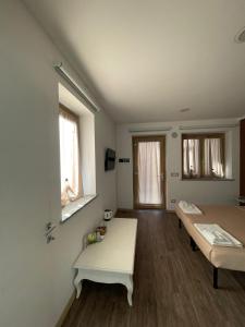 a room with two beds and a table in it at Le Ghie in Mondovì