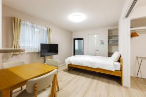 a bedroom with a bed and a table and a dining room at Anecis笠取町1 in Nagoya