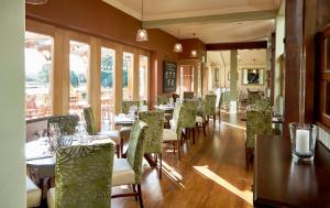 uma sala de jantar com mesas, cadeiras e janelas em The Golden Pheasant em Knutsford