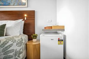 a room with a refrigerator next to a bed at Darwin CBD Escape-Cosy and Central in Darwin
