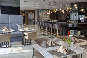 a restaurant with tables and chairs and a bar at Novotel Suites at Acqua in Manila