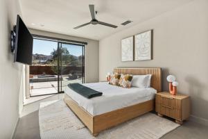 a bedroom with a bed and a flat screen tv at Suncrest by Fieldtrip - JT Modern w Pool and Views in Joshua Tree +28 photos