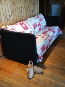 a couch with a pair of shoes on the floor at Maison De Marthe in Doues