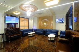 a waiting room with leather furniture and a flat screen tv at HOTEL BREEZE BAY EX - NEAR US Consulate, BKC in Mumbai