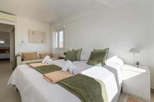 two beds in a white room with green pillows at Hawaii in Jávea +3 photos