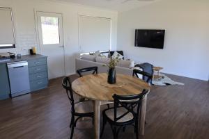 a living room with a table with chairs and a couch at Rivergums Cottage in Dubbo