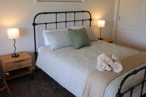 a bedroom with a bed with towels on it at Rivergums Cottage in Dubbo