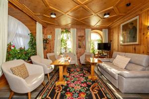 a living room with a couch and a table and chairs at Hotel Pontechiesa in Cortina dʼAmpezzo