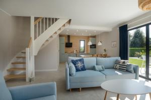 a living room with a blue couch and a staircase at Osada plażowa in Białogóra