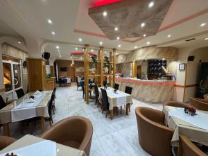 a restaurant with white tables and chairs and a bar at Motel Grand in Rožaje