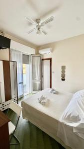 a bedroom with a large bed with a ceiling fan at Hotel B&B Avana in Lido di Savio +32 photos