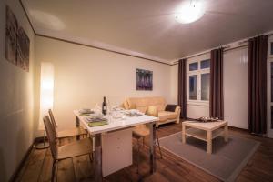 uma sala de estar com uma mesa e um sofá em Chalet Cecile em Interlaken