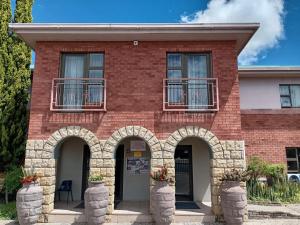 a red brick building with two arches at Airport Hotel in Kimberley