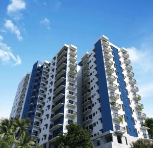 an apartment building with blue balconies and palm trees at Colombo lotus tower view Apartment in Colombo