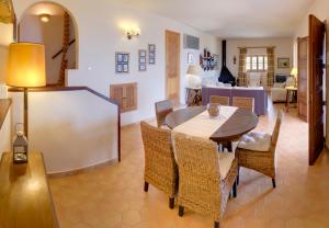 a dining room and living room with a table and chairs at La Galera Deià in Deia