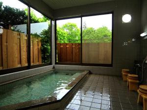 a swimming pool in a bathroom with windows at Bunanoyado Koase in Aga