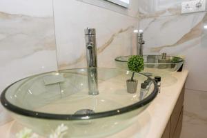 a glass sink in a bathroom with a faucet at Relaxury Villa III in Karpathos
