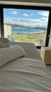 a bedroom with a bed and a large window at Relaxury Villa III in Karpathos