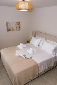 a bedroom with a bed with towels on it at Relaxury Villa III in Karpathos