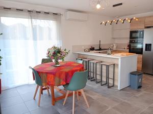 a kitchen with a table with a vase of flowers on it at Maison individuelle 6 personnes in Coux +3 photos
